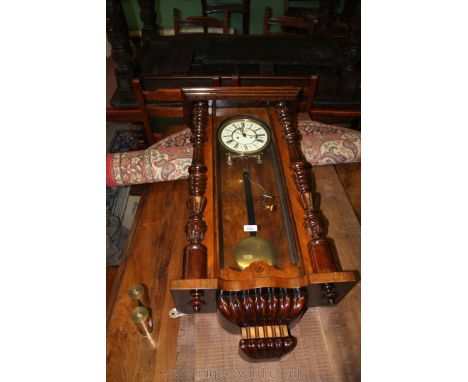 A Victorian Mahogany cased Vienna Wall Clock having moulded cornice, single glazed door with half turned fluted columns flank