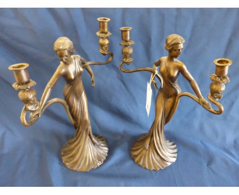 A pair of modern art nouveau style bronze candelabra depicting scantily clad female figurines.