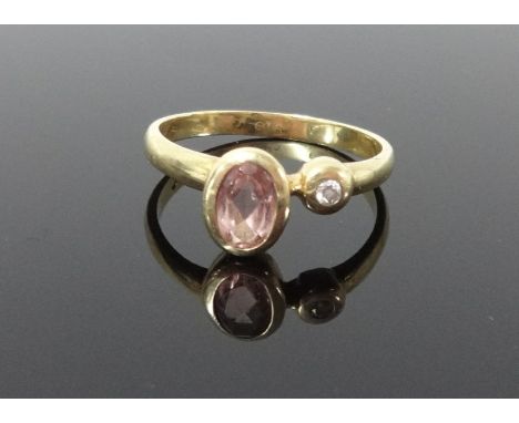 A yellow metal dress ring set with a single diamond and another coloured stone, size K.