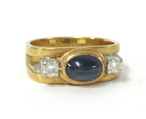 A poulson cabochon sapphire and diamond three stone ring, size K.