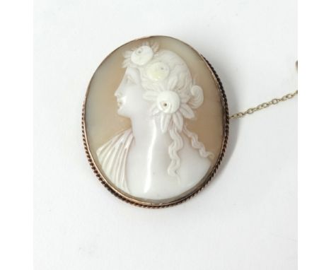 A yellow metal set cameo brooch with a portrait of a lady.