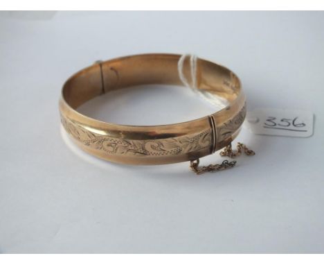 AN ENGRAVED HINGED BANGLE IN 9CT - 16.gms