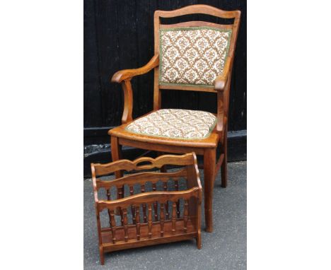 A 20thC oak armchair, with serpentine comb top, overstuffed back and seat, shaped arms and sabre front supports joined by a p
