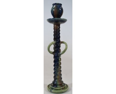 An early 20thC Dresser style Studio pottery candlestick, with urn top, lipped dish holder, entwined stem and triple handles, 