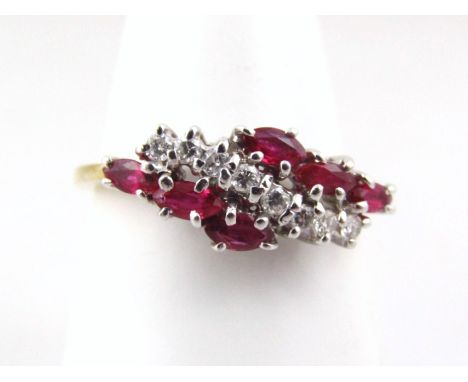 An 18ct gold ruby and diamond dress ring, set with eight tiny diamonds, and six oval cut rubies, in a platinum claw setting, 