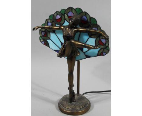 A modern Art Deco style table lamp, formed as a lady in flowing robes with leg and arms outstretched with a fan shaped froste