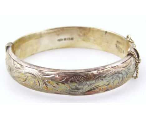 A silver bangle, with half florally engraved design, Birmingham assay, 20.6g.
