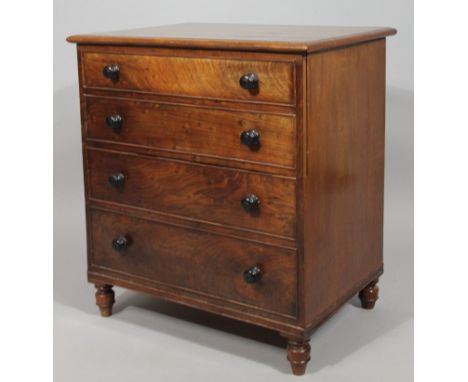 A George III mahogany commode chest, the rectangular moulded overhanging top articulating at the centre, on turned supports, 