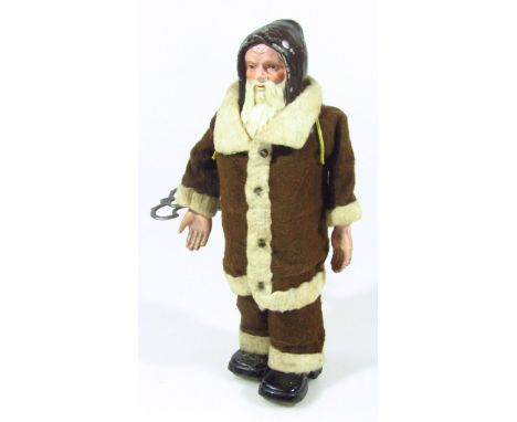 An early 20thC tin plate clockwork walking figure of Father Christmas, possibly Ives, USA, in brown and white dress with blac