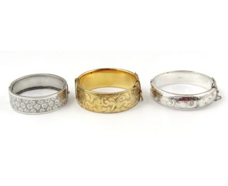 Three bangles, to include a silver bangle marked Birmingham 1882, another silver bangle, and a gold coloured smaller engraved