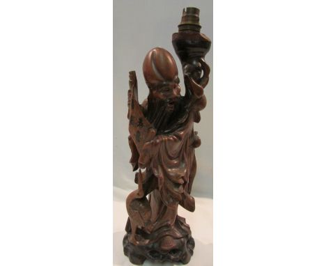 A carved wooden figural table lamp, Chinese wise man with scroll and crane, height including light fitting 40cm