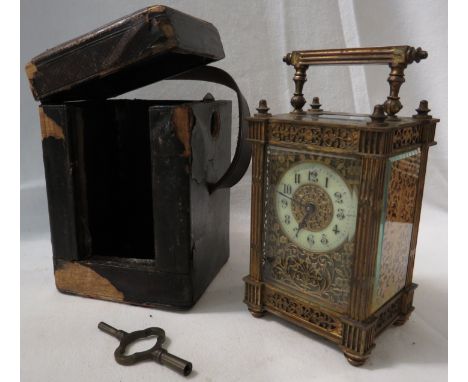 A heavy brass carriage clock with blind fret tracery and reeded square pilasters to the corners, with bevelled glass panels. 