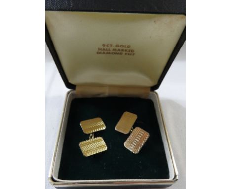 A pair of yellow metal cufflinks, rectangular with engine turned lines, stamped 9ct, combined weight 5.2g, in blue presentati