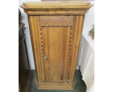 A single door cupboard constructed in large from the pine trunk of an 18th century or earlier clock, the single door enclosin