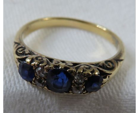 A ring set with three graduated sapphires spaced with two pairs of small diamonds, the largest central sapphire about 4mm x 3