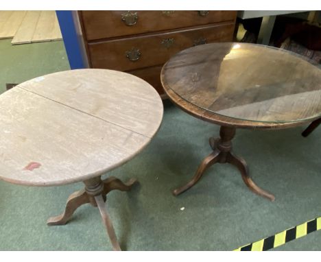 2 circular pedestal tables, both with wear, dark one uneven, light one with crack on top 