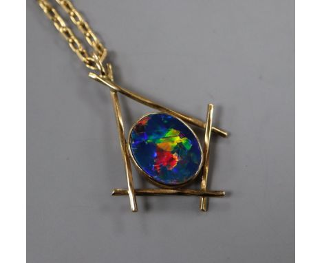 A modern yellow metal and black opal doublet pendant, on a 9ct chain, pendant 31mm.