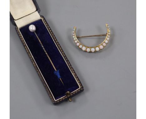 A yellow metal and graduated white opal set crescent brooch and a cased tie pin.