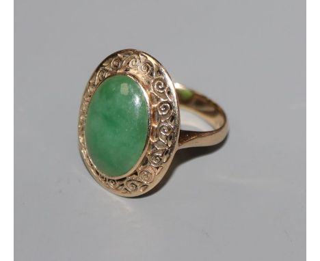 A yellow metal and oval cabochon jade dress ring, size I.