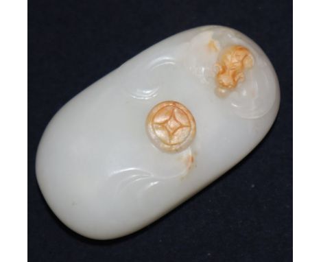 A Chinese white and russet jade pebble