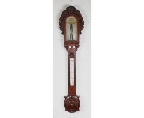 A VICTORIAN CARVED OAK STICK BAROMETER by HILLS, SUDBURY, with silvered dial and ivory mounted thermometer. 41ins long.