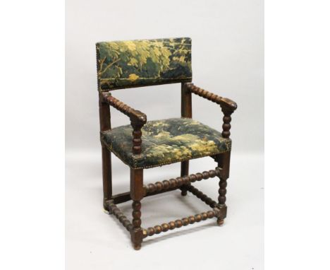 A SMALL 17TH CENTURY ITALIAN WALNUT ARMCHAIR with tapestry back and seat, on bobbin turned supports.