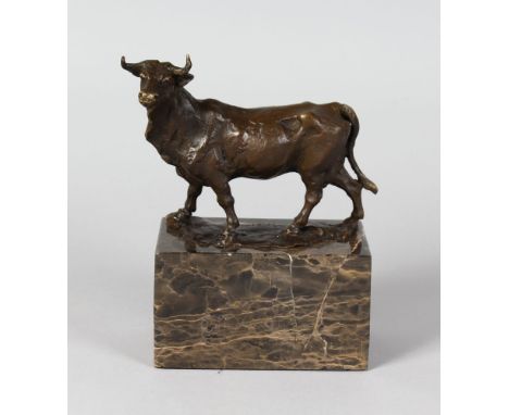L. CARVIN A SMALL BRONZE OF A COW.  5ins long. Signed, on a marble plinth.