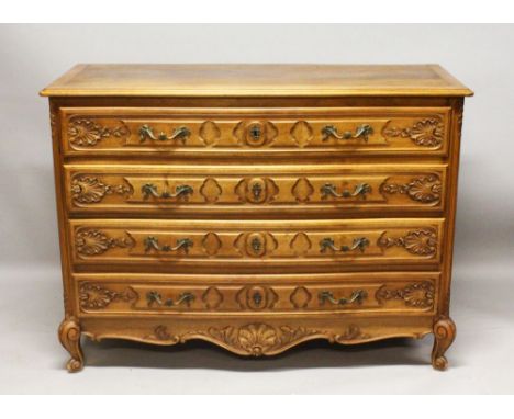 A LATE 19TH CENTURY FRENCH WALNUT COMMODE, the four drawers with carved decoration and ornate cast brass handles on cabriole 