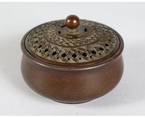 A CHINESE BRONZE CIRCULAR CENSER with pierced cover. Impressed mark.  3ins diameter.