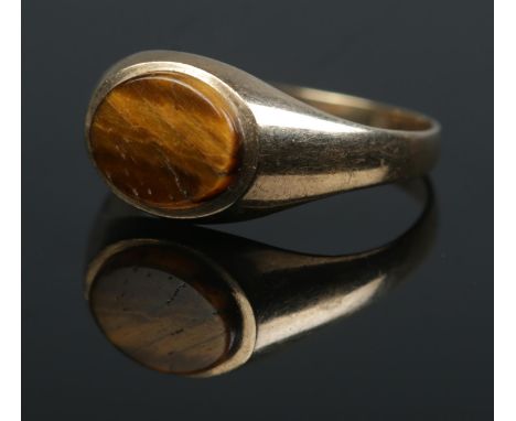A 9ct gold ring set with a Tiger's Eye stone. Size R. 2g.  