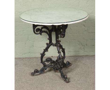 A marble topped circular table, with cast iron Tavern style tripod base. Height: 72cm, Diameter: 76cm.  Some chips to the tab