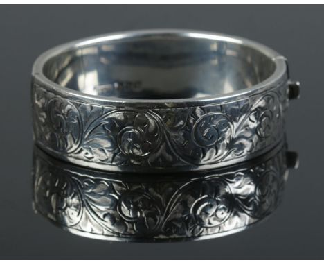 A 925 silver etched hollow bangle with hinge, assayed for Birmingham 1971, 28.8 grams.  has some small dents.