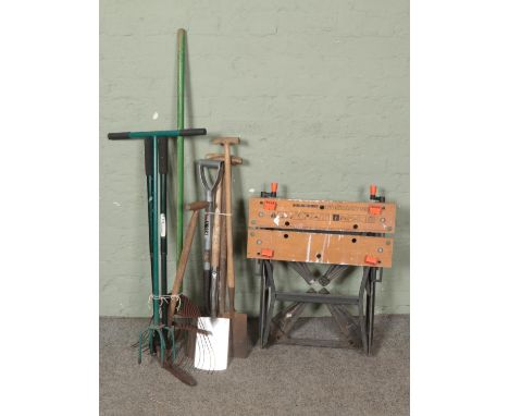 A collection of garden tools including shovel, rake, forks and workmate bench.  