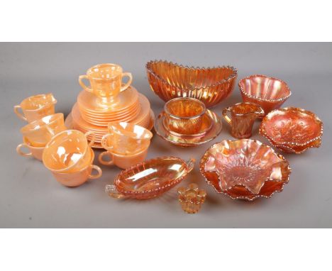 A collection of Fire King oven ware. In orange lustre finish. Cups/ saucers, side plates, milk jug etc together with a select