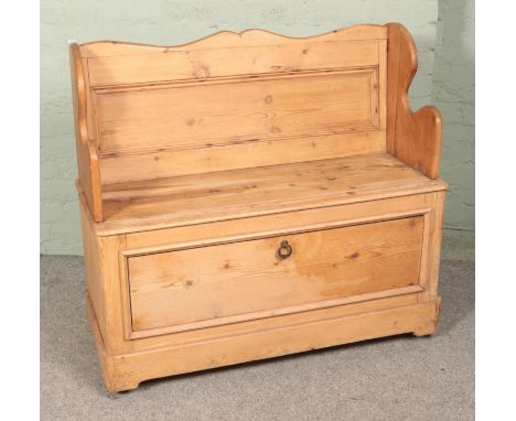 A pine hall bench/settle with lower storage compartment.Hx98cmWx105cmDx46cm  Signs of historic wood worm and door for storage