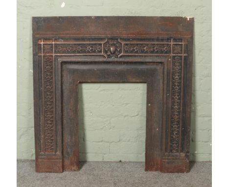 A cast iron fireplace surround plate, featuring a geometric floral border and central urn. Height: 96cm, Width: 96cm.  