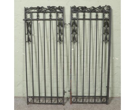 A decorative pair of iron gates, with entwined foliage detailing to the top. Height: 122cm, Width (of each gate): 51cm.  