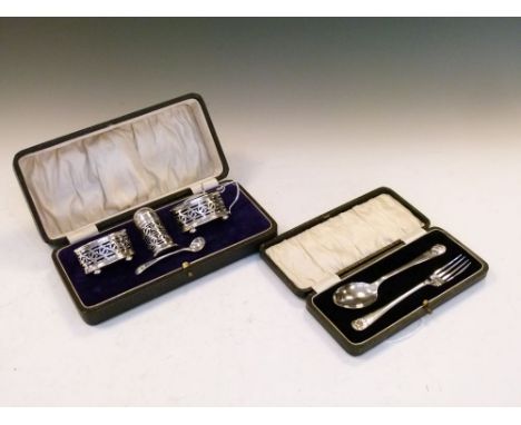 George V cased silver cruet set comprising: oval mustard pot and salt and cylindrical pepperette, each of pierced design with