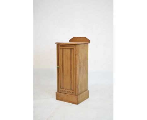 Stripped pine bedside cabinet or night cupboard with reeded door enclosing shelf, 33cm wide x 84cm high  