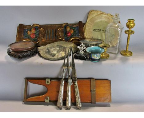A miscellaneous collection of items to include a gold painted book slide, a polished ammonite fossil, a glass bottle, a woode