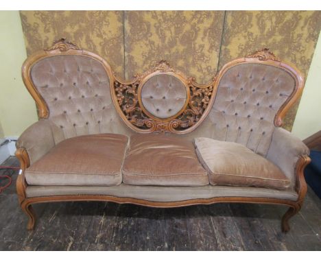 A continental sofa with carved and moulded show wood frame, the cameo back flanked by further carvings, raised on cabriole su