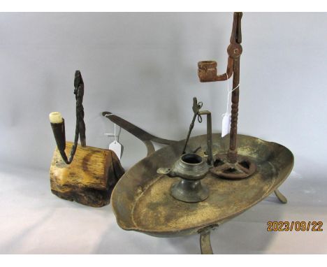 Two wrought iron 19th century nip/rush light holders, one set in a chunk of wood. 