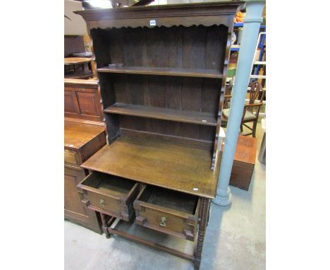 A small oak cottage dresser in a Jacobean style fitted with two frieze drawers on bobbin supports with plate rack above, 92 c
