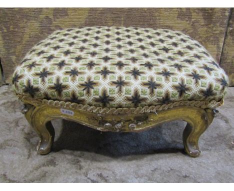 A Victorian gilded foot stool on carved and cabriole supports with handworked tapestry top 