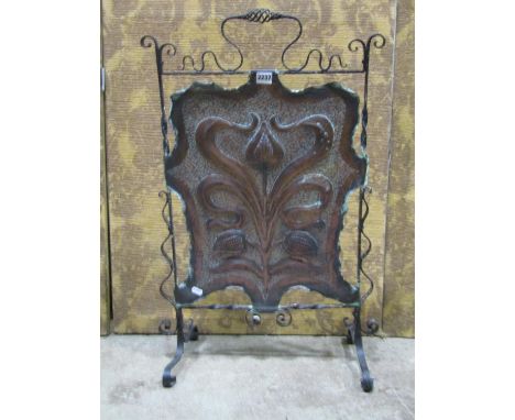 An art nouveau ironwork and hammered copper firescreen on scrolled supports 