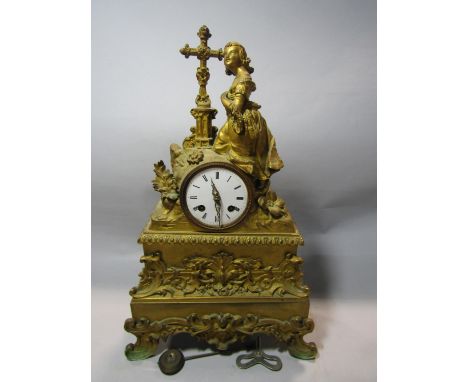 Early 19th century gilded brass mantle clock, the detailed case surmounted by a young girl beside a cross, enclosing an eight
