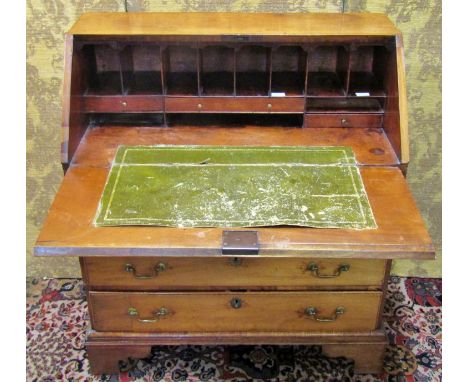 A Georgian countrymade bureau in mahogany and pine, four long graduated drawers, the fall flap enclosing a simply fitted inte