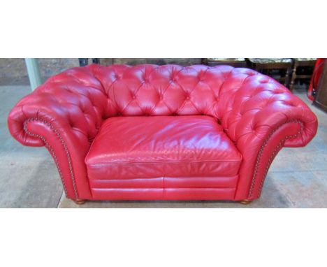 A Chesterfield double seat/small sofa with buttoned finish in a red leather colourway 