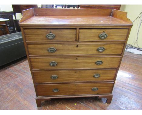 A Georgian mahogany chest of four long and two short graduated drawers set beneath a three quarter gallery raised on bracket 