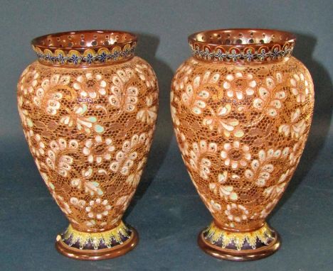 A pair of Doulton Lambeth oviform vases with pierced rims, and floral detail, three graduated Poole Pottery leaping dolphins,